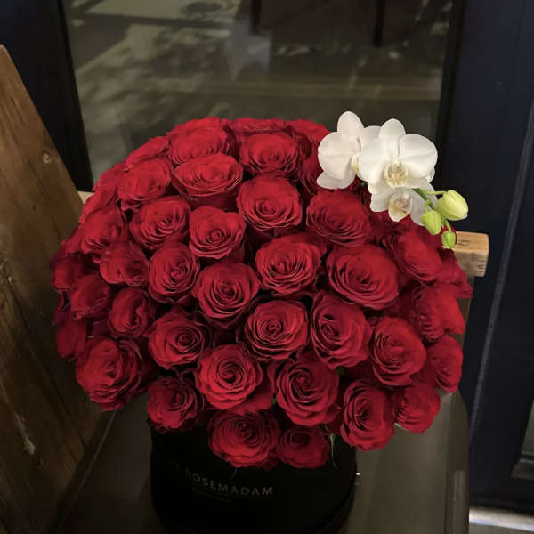 Large red rose arrangement with white orchids in a black hat box