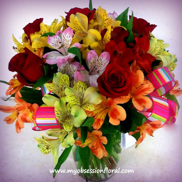 Bouquet of red roses and colorful alstroemeria with striped ribbon