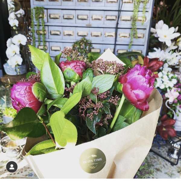 Bouquet of pink peonies wrapped in beige paper