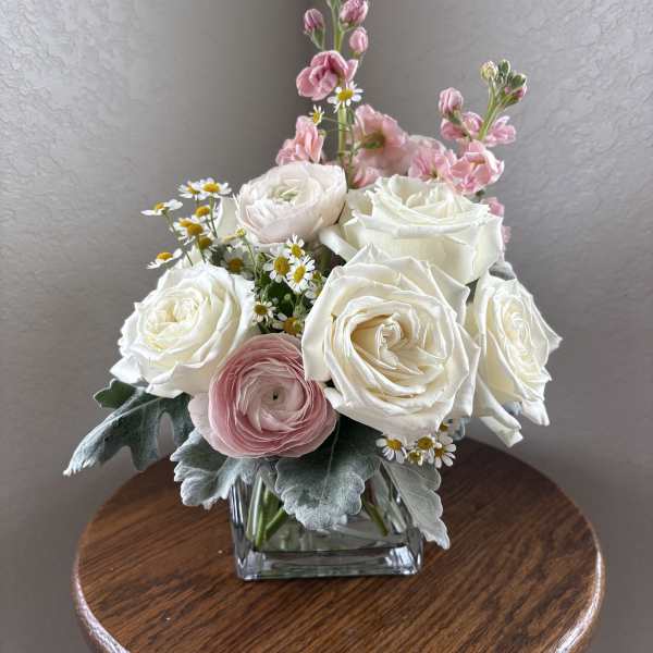 Pink and white rose bouquet in a square glass vase