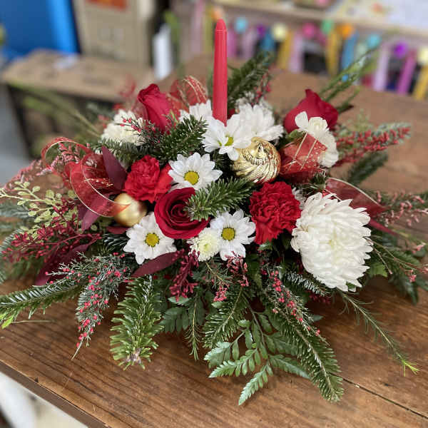 Red and white floral centerpiece with a pink candle and gold ornaments