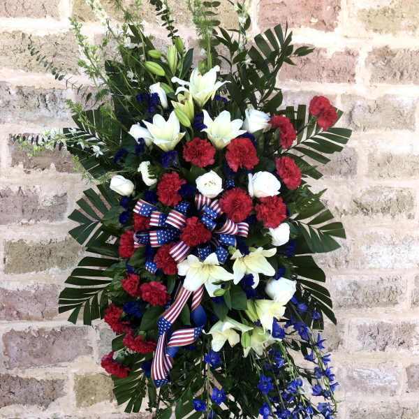 Standing floral spray with red, white, and blue flowers and ribbon