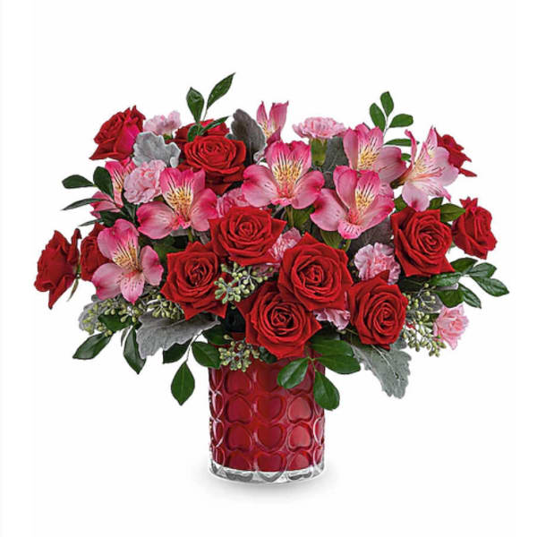 Red roses and pink alstroemeria in a red heart-pattern vase