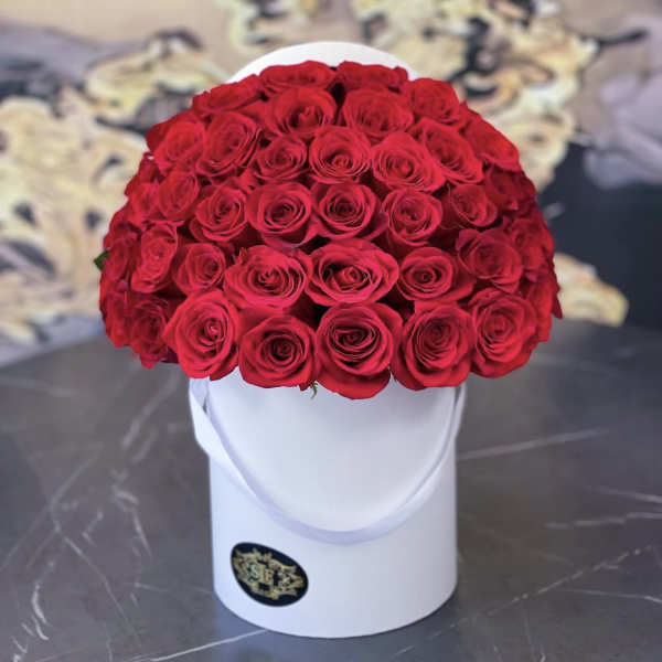 Round bouquet of red roses in a white hat box