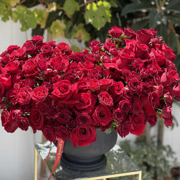 Large arrangement of red roses in a dark vase