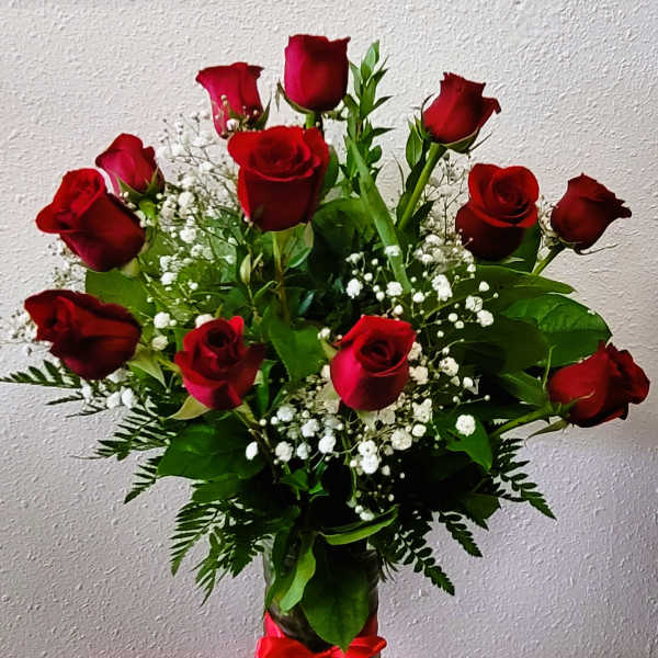 Bouquet of red roses with baby's breath in a glass vase