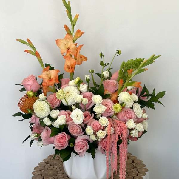 Pink and white floral arrangement in a white vase