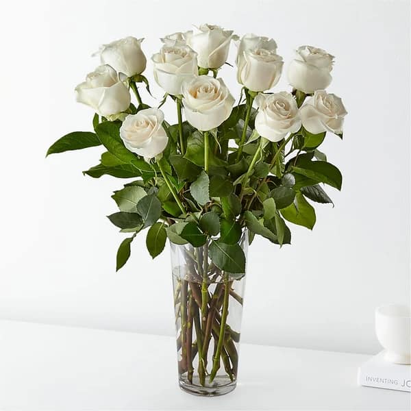 White roses arranged in a clear glass vase