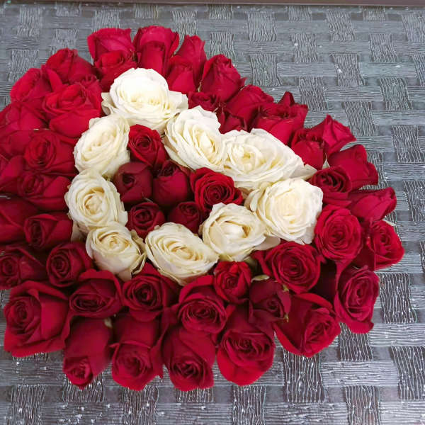 A large arrangement of red and white roses laid in a circular pattern.