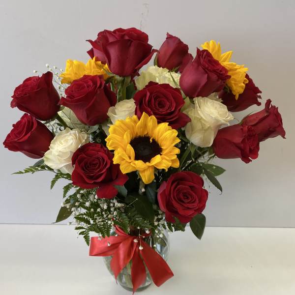 Bouquet of red and white roses with a sunflower in a glass vase