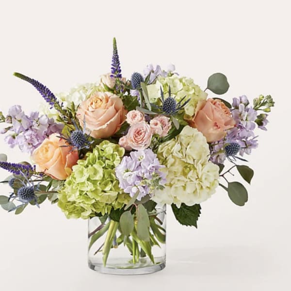 Bouquet of peach roses and hydrangeas in a clear glass vase