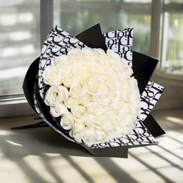 Bouquet of white roses wrapped in black-and-white patterned paper
