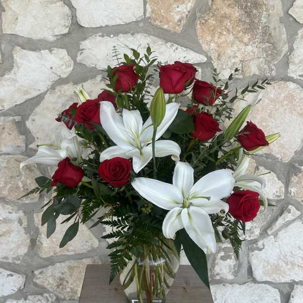 Red roses and white lilies in a clear glass vase