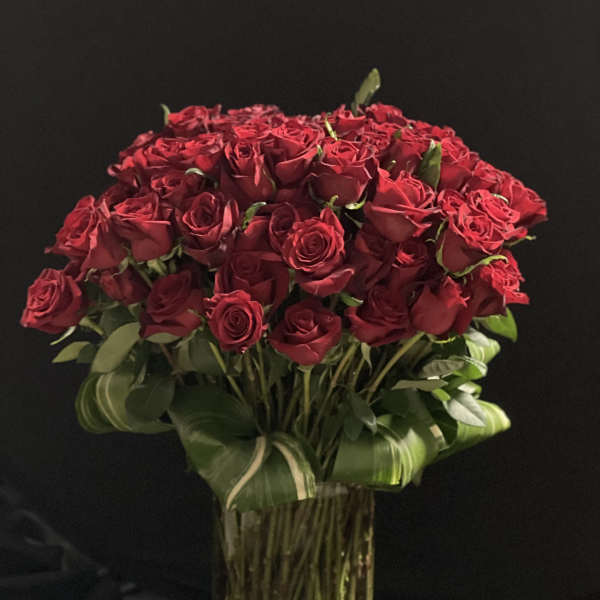 Bouquet of red roses in a tall glass vase