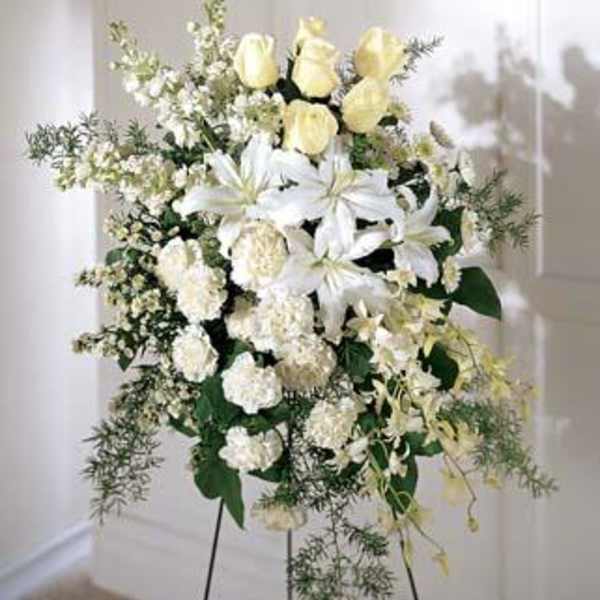 White floral standing spray on a black easel