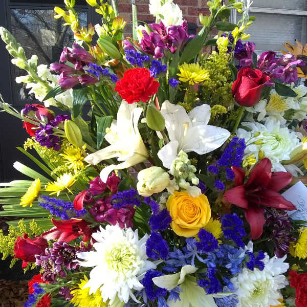 Large mixed bouquet with lilies, roses, and daisies in bright colors