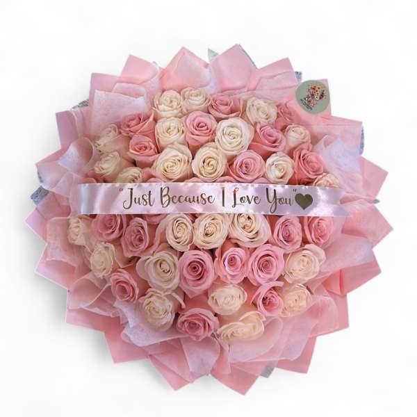 Bouquet of pink and cream roses wrapped in pink paper with a love-you ribbon