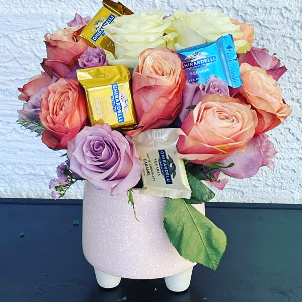 Pink and peach roses with Ghirardelli chocolates in a pink vase