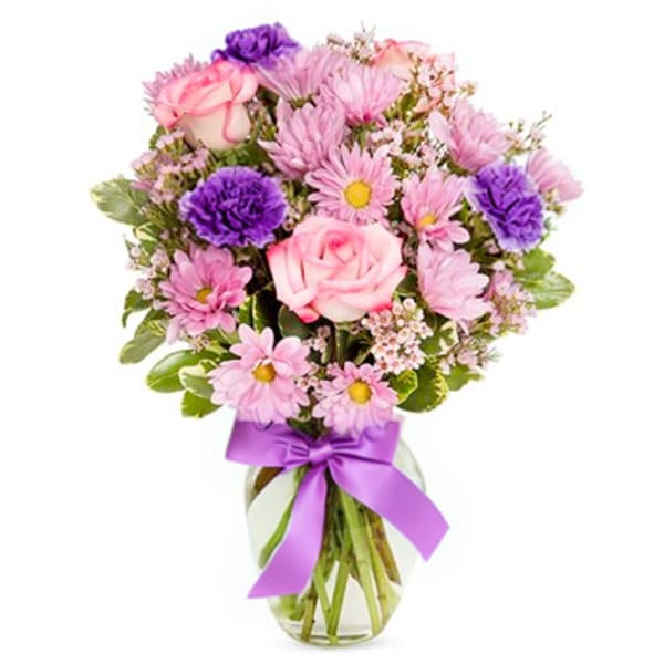 Pink and purple mixed bouquet in a glass vase with a ribbon