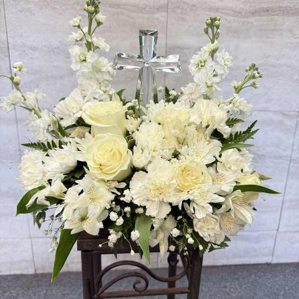 White floral arrangement with a silver cross centerpiece