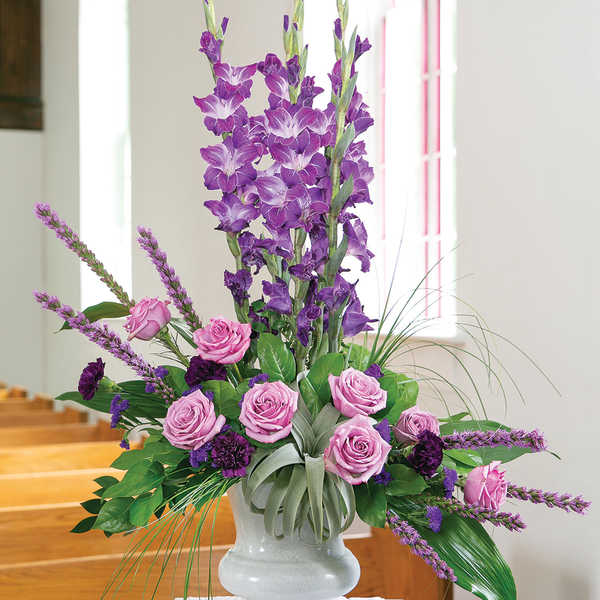 Purple and pink floral arrangement in a white vase