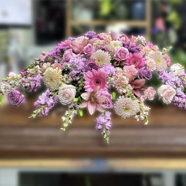 Casket spray of pink and lavender flowers