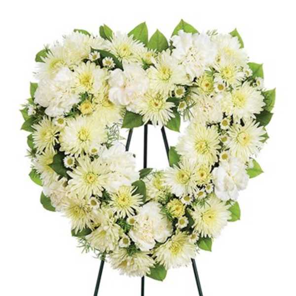 Heart-shaped white floral wreath on a stand