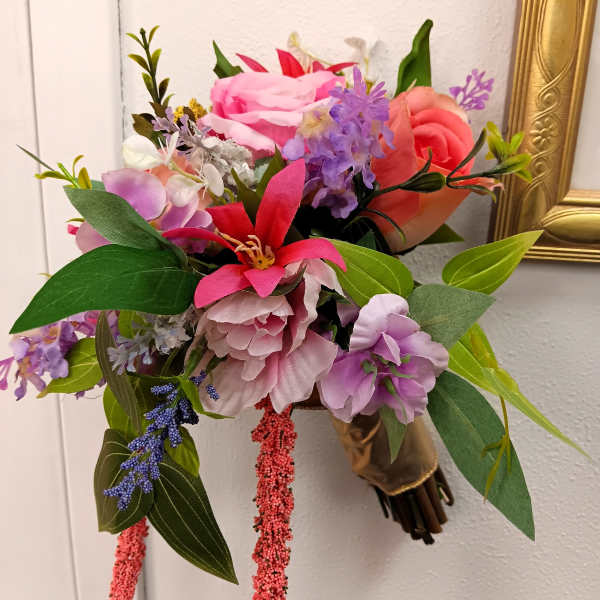 Colorful bouquet of pink, purple, and coral flowers with long green leaves