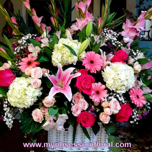 Large pink and white floral arrangement in a white basket