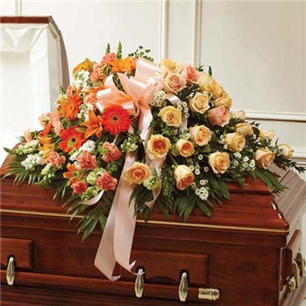 Floral casket spray with peach roses and orange gerbera daisies