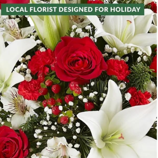 Red roses and white lilies with red carnations in a holiday bouquet