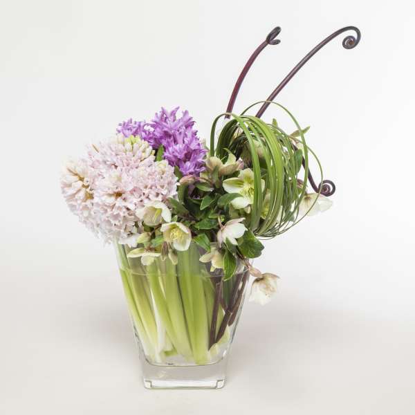 Lavender and white flowers arranged in a clear glass vase