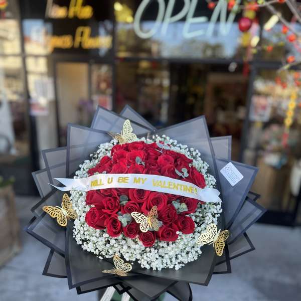 Large bouquet of red roses with white baby's breath and gold butterfly accents