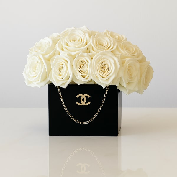 White rose arrangement in a black box with a gold chain detail