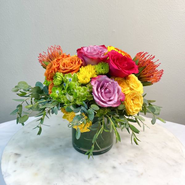 Colorful bouquet of roses and mixed blooms in a glass vase