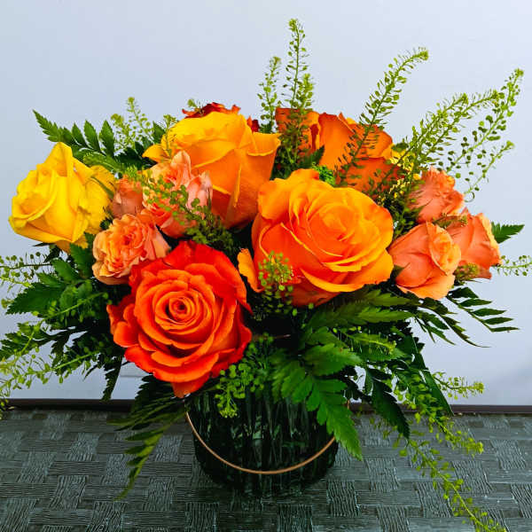 Bouquet of orange and yellow roses in a glass vase