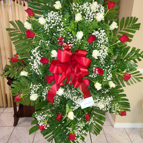 Standing floral spray with red and white roses and a red ribbon