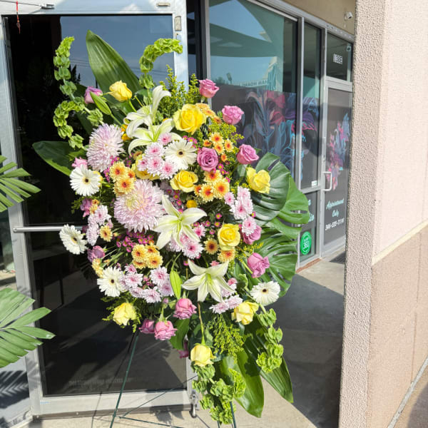 Large standing floral spray with roses, lilies, and daisies
