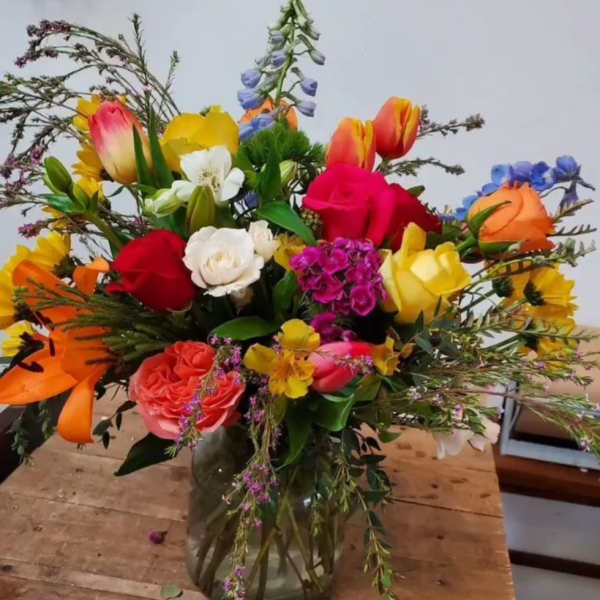 Colorful mixed bouquet in a glass vase with roses and tulips