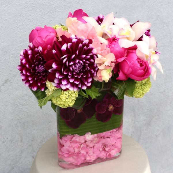 Pink and purple floral arrangement in a clear rectangular vase