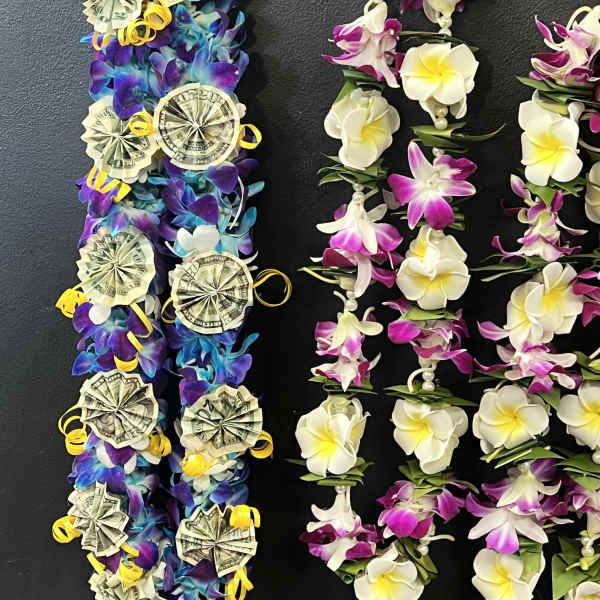 Lei-style floral garlands with white and purple flowers and money rosettes