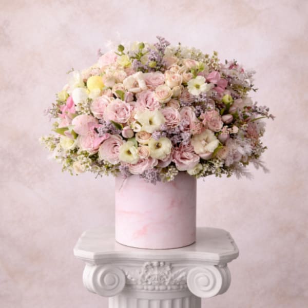 Pastel bouquet of pink and white flowers in a pink cylindrical box