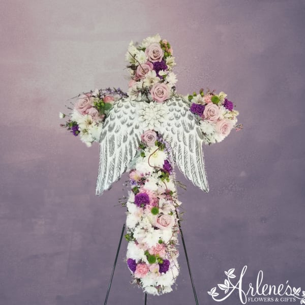 Standing floral angel cross in pink, white, and purple flowers on an easel stand