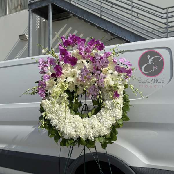 Large floral wreath of white and purple orchids on a stand