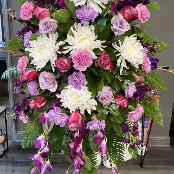 Tall floral spray with white chrysanthemums, pink roses, and purple blooms