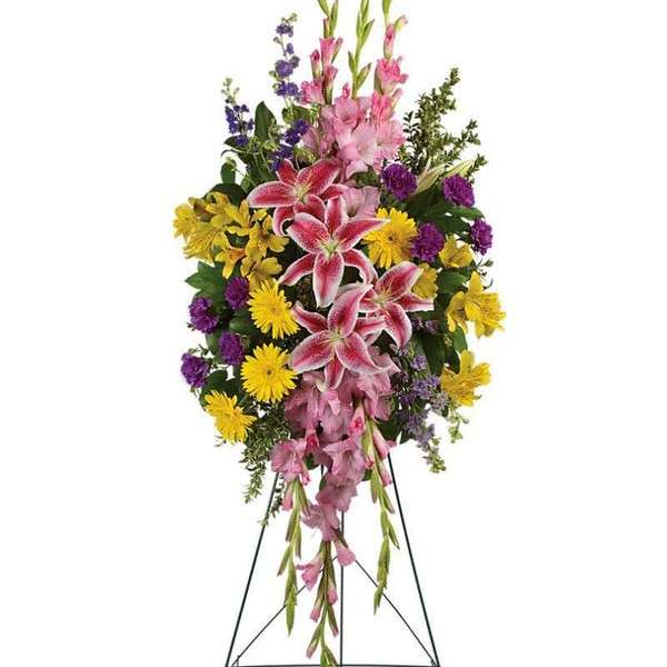 Tall standing floral spray with pink lilies, yellow daisies, and purple flowers