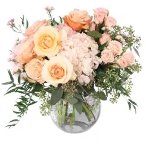 Peach and blush rose bouquet in a clear glass vase