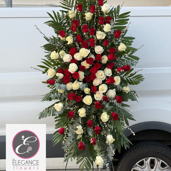 Standing spray of red and white roses with palm fronds