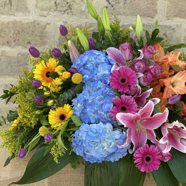 Colorful mixed bouquet with blue hydrangeas, pink lilies, and roses