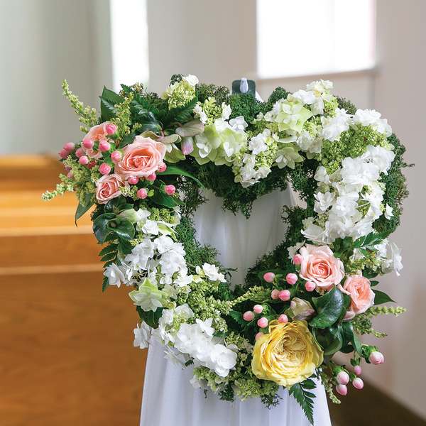 Heart-shaped floral wreath with pink, white, and yellow flowers